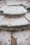 Several steps of an old and ruined vintage staircase made of white stone