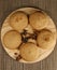 several sweet round cookies with cracks of light brown color lie on a wooden kitchen brown stand
