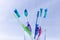 Several toothbrushes of different colors in a base and white background