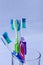 Several toothbrushes of different colors in a base and white background