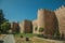 Several towers on the city wall and green garden at Avila