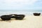 Several traditional bamboo coracle boats on a sandy beach with surf and blue sky in Vietnam