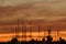 Several transmission antennas against an orange cloudy sky