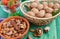 Several types of nuts in a brown bowl of strawberries in a transparent glass healthy food on a green background