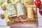 Several types of rolls in colorful pita bread on a white wooden background