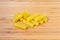 Several uncooked tortiglioni pasta close-up on wooden surface