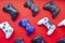 Several video game control remote from the most popular game consoles on a red background