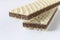 Several wafers with chocolate on a light background. Selective focus