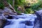 Several waterfalls passing under a wooden bridge.