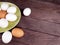 Several white and brown eggs in a ceramic plate and next to a plate on a table