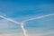 Several white condensation airplane trace in deep blue sky