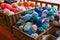 Several  wicker baskets of knitting wool for sale, mostly blues and oranges
