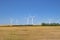 Several wind tower turbine electricity generators on a farm. Renewable energy source on a farm field