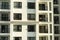 Several windows in a row on facade of urban apartment building front view in Hanoi, Vietnam