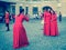 Several women in identical red dresses taking photos of each other against the background of the sights of St. Petersburg. Russia.