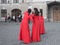 Several women in identical red dresses taking photos of each other against the background of the sights of St. Petersburg. Russia.