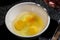 Several yolks and white egg into a ceramic bowl