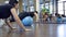 Several young women stand on fitball knees during training.