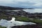 Severe gloomy highlands norway landscape - granite high shore with green moss, lakes, grey Arctic Ocean in cloudy weather.