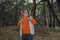 Severe senior ranger with two rifles standing in dark pine forest