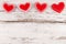 Sewed Pillow Hearts Row Border from Red Fabric at Rustic White Wood Background