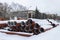 Sewer pipes lie on a construction site, covered with snow