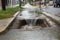 sewer water overflowing onto the sidewalk and into storm drain