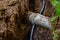 Sewer and water pipes in an excavated trench deep in the ground, close up.