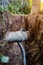 Sewer and water pipes in an excavated trench deep in the ground, close up.