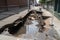 sewer water spilling out of the broken pipes onto the sidewalk