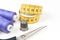 Sewing accessories and tools, medium purple sewing threads, yellow measuring tape with black numbers, scissors and metal thimble o