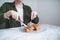 Sewing and knife in the hands of a girl cut a sandwich in a plate. A woman eats a sandwich in a light restaurant