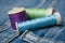 Sewing thread spool bobbin on blue jeans background