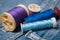 Sewing thread spool bobbin on blue jeans background