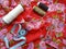 Sewing tools: colored sewing threads, centimeter ribbons and colored pins on a red background close-upÐ²Ñ†