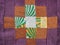 Sewn patchwork cloth with brown on purple fabric