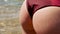 Sexual round female buttocks in red swimsuit