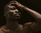 Sexy Afro-American man shows face palm gesture. portrait of a naked man standing with closed eyes on black background