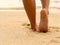 Sexy Asian women legs foot step on tropical sand beach. Walking female feet sand beach leaving footprints