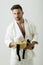 Sexy athlete, karatek with black belt. Strength and attractiv, perfect guy on white background. Kimono on the bare chest