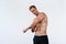 Sexy athletic man with naked torso on white background. Fashion portrait of sporty healthy guy