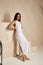 Sexy beautiful woman brunette tanned skin makeup cosmetic fashion clothes summer collection white cotton dress accessory bag style