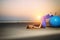 Sexy blonde with fitness ball on the beach outdoors. Beauty lies on the sand in the evening light against the sunset over the sea