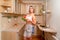 Sexy blonde housewife with tomatoes and cucumbers at kitchen