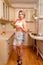 Sexy blonde housewife with tomatoes and cucumbers at kitchen