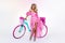 Sexy blonde model in amazing dress on colorful bike, decorated with flowers. Spring concept. Beautiful natural woman in elegant