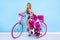 Sexy blonde model in amazing dress on colorful bike, decorated with flowers. Spring concept. Beautiful natural woman in elegant