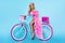 Sexy blonde model in amazing dress on colorful bike, decorated with flowers. Spring concept. Beautiful natural woman in elegant