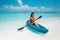 Sexy brunette paddling a kayak. Woman exploring calm tropical bay. Maldives. Sport, recreation. Summer water sport, adventure