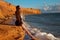 Sexy brunette summer girl with long healthy hair enjpying on the beach at sunset. Freedom summertime vacation concept. Enjoyment